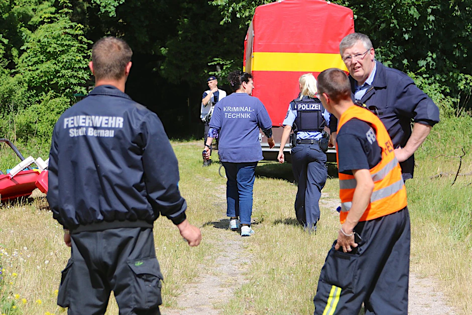 Feuerwehr und Polizei bergen die Leiche aus einem dicht bewachsenen Grundstück bei Bernau.