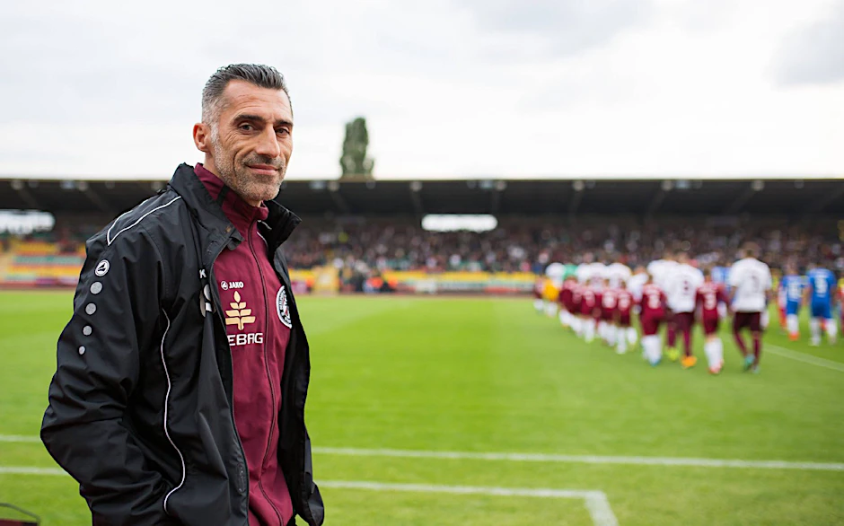 Thomas Stratos lächelt in die Kamera, im Hintergrund läuft sein BFC aufs Spielfeld. So entspannt würde der Dynamo-Coach die Regionalliga gerne aufmischen.