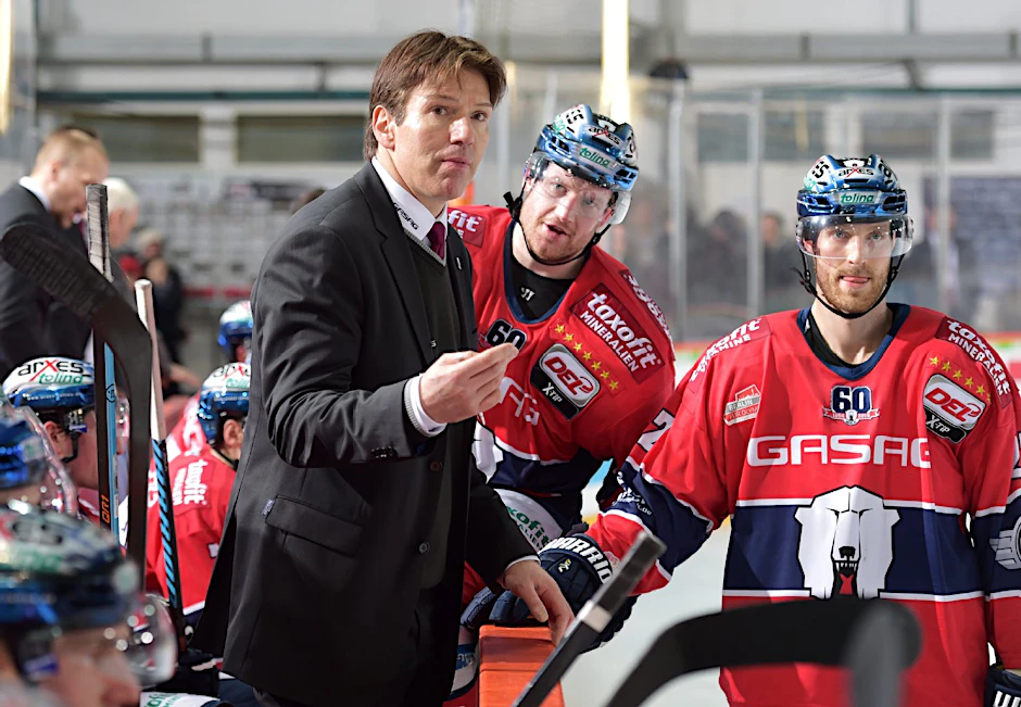Eisbären-Trainer Uwe Krupp erklärt und Matthew Foy und Barry Tallackson hören zu (v.l.).