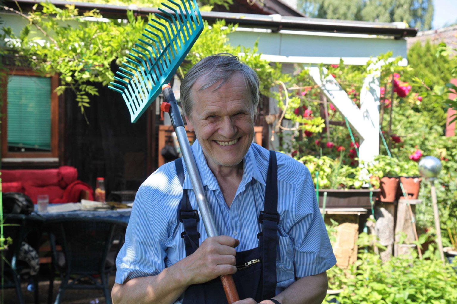 Allzeit bereit für Gartenarbeit. Wolfgang Krüger, mit einem Rechen bewaffnet, hat sich bis vor wenigen Jahren nicht vorstellen können, einmal Laubenpieper zu sein.