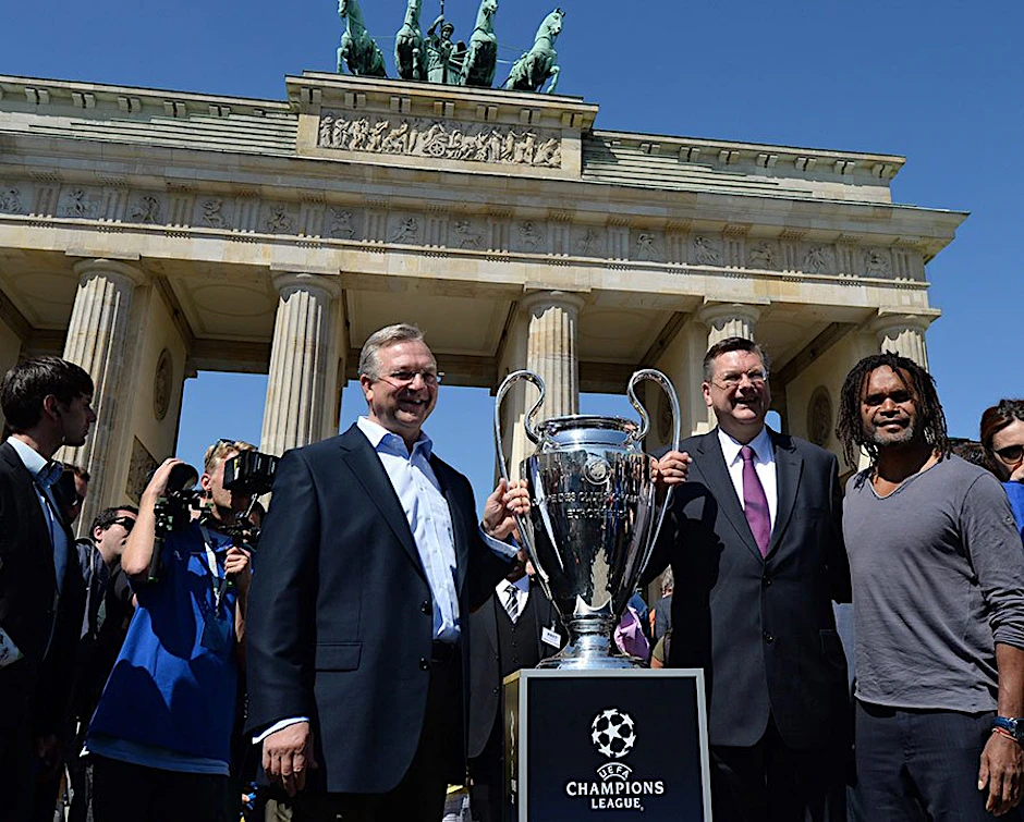 Senator Frank Henkel (li.) und DFB-Schatzmeister Rainer Grindel und der frühere Real-Madrid-Profi Christian Karembeu präsentieren vor dem Brandenburger Tor den Champions-League-Pokal.