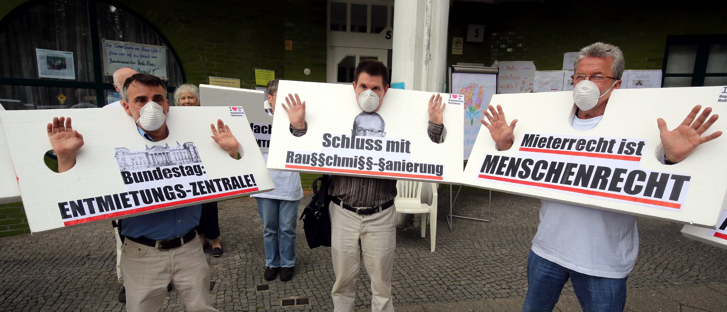 Mitglieder der Künstlergruppe "Büro für ungewöhnliche Maßnahmen" (BfM) erklären sich mit Schildern mit der Aufschrift "Bundestag: Einmietungs-Zentrale!", "Schluss mit Rausschmiss-Sanierung" und "Mieterrecht ist Menschenrecht" solidarisch mit den Bewohnern.