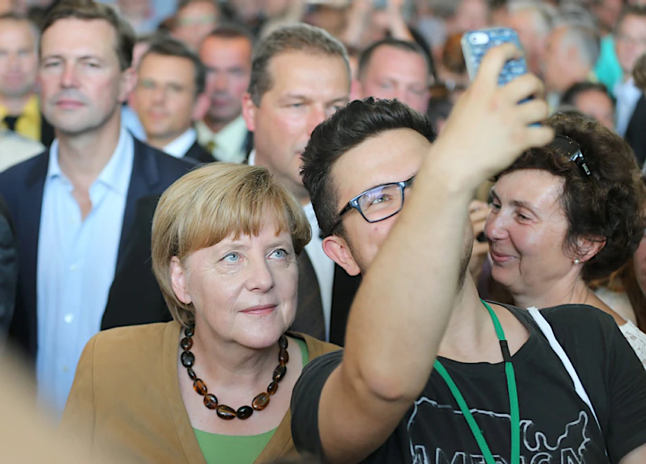Bundeskanzlerin Angela Merkel (CDU) begrüßt im Bundeskanzleramt am Tag der offenen Tür der Bundesregierung Bürger. Ein Fan macht ein Selfie mit ihr.