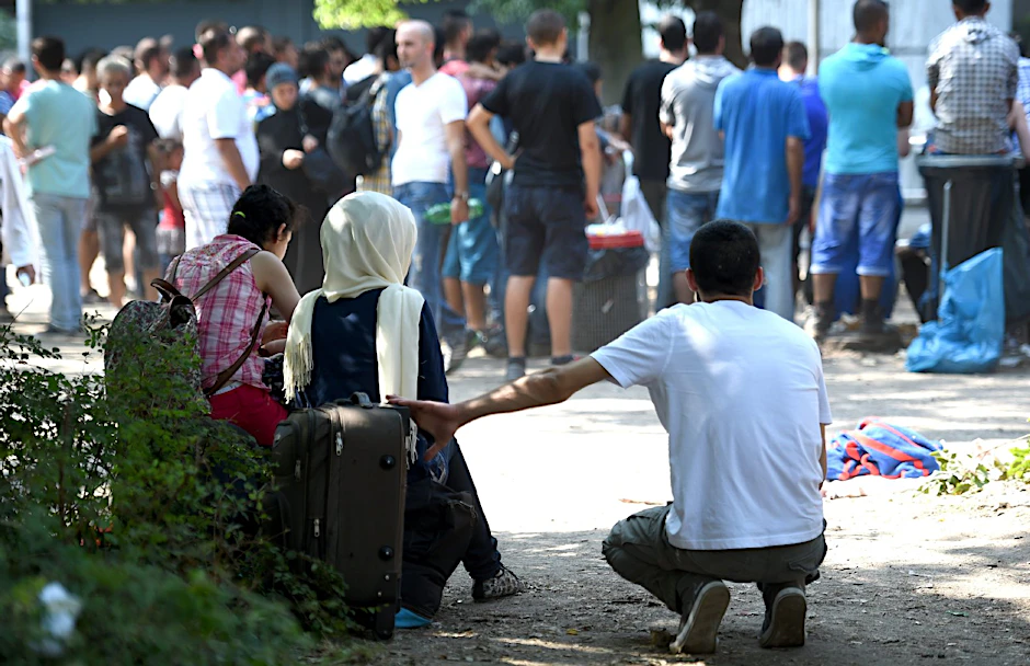 Flüchtlinge warten auf dem Gelände des Landesamtes für Gesundheit und Soziales (LaGeSo) in Berlin in der Hitze.