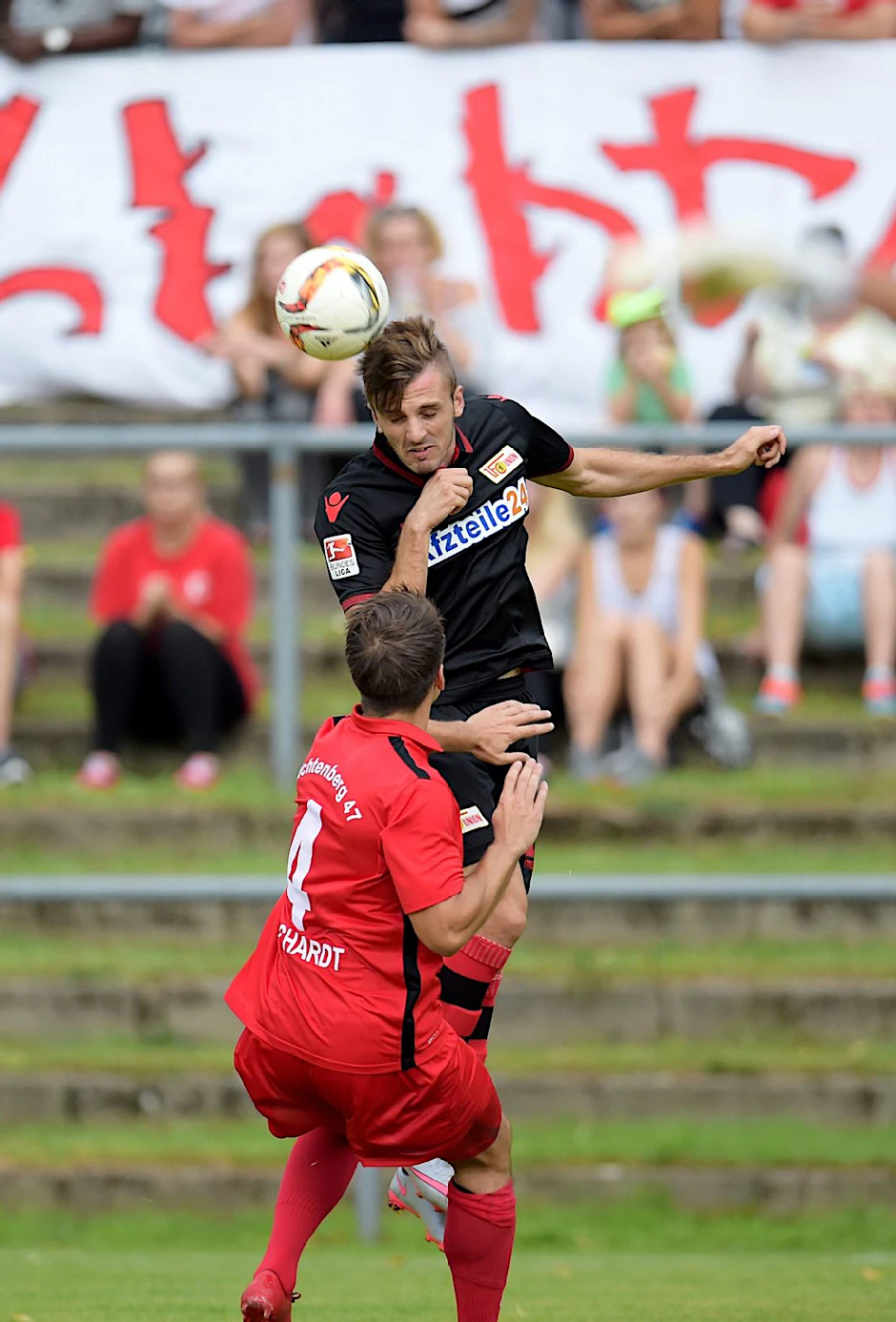 Adrian Nikci (h.) köpft, Lichtenbergs Geoffrey Borchardt kommt zu spät.