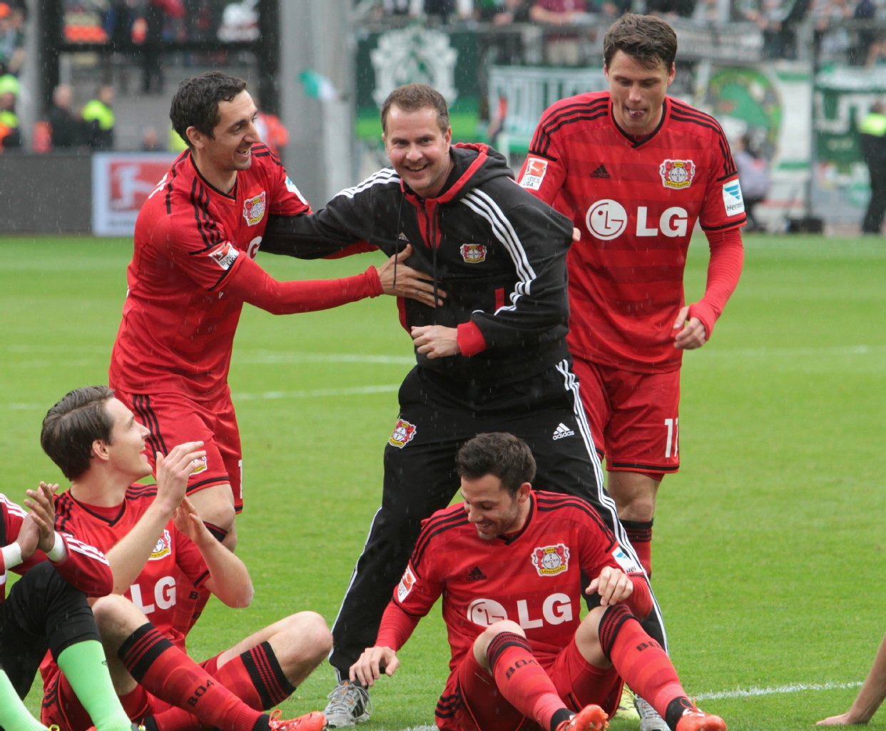 Sascha Lewandowski (M.) war bei Bayer beliebt. Hier versucht Roberto Hilbert, ihn zu den Fans zu bewegen. Später feierte er auf dem Zaun mit den Anhängern.
