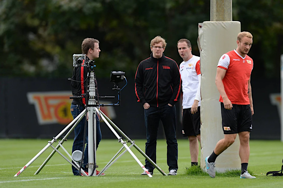 Die Videoanalysten Ross Simpson und Adrian Wittmann besprechen mit Trainer Sascha Lewandowski (2.v.r.) die neue, auf neun Meter Höhe ausfahrbare Technik. Toni Leistner (r.) macht sich aus dem Staub.