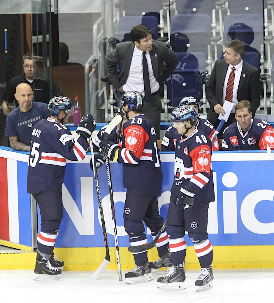 Trainer Uwe Krupp gibt seinen Eisbären an der Bande die Anweisungen für die nächsten Spielzüge auf dem Eis.
