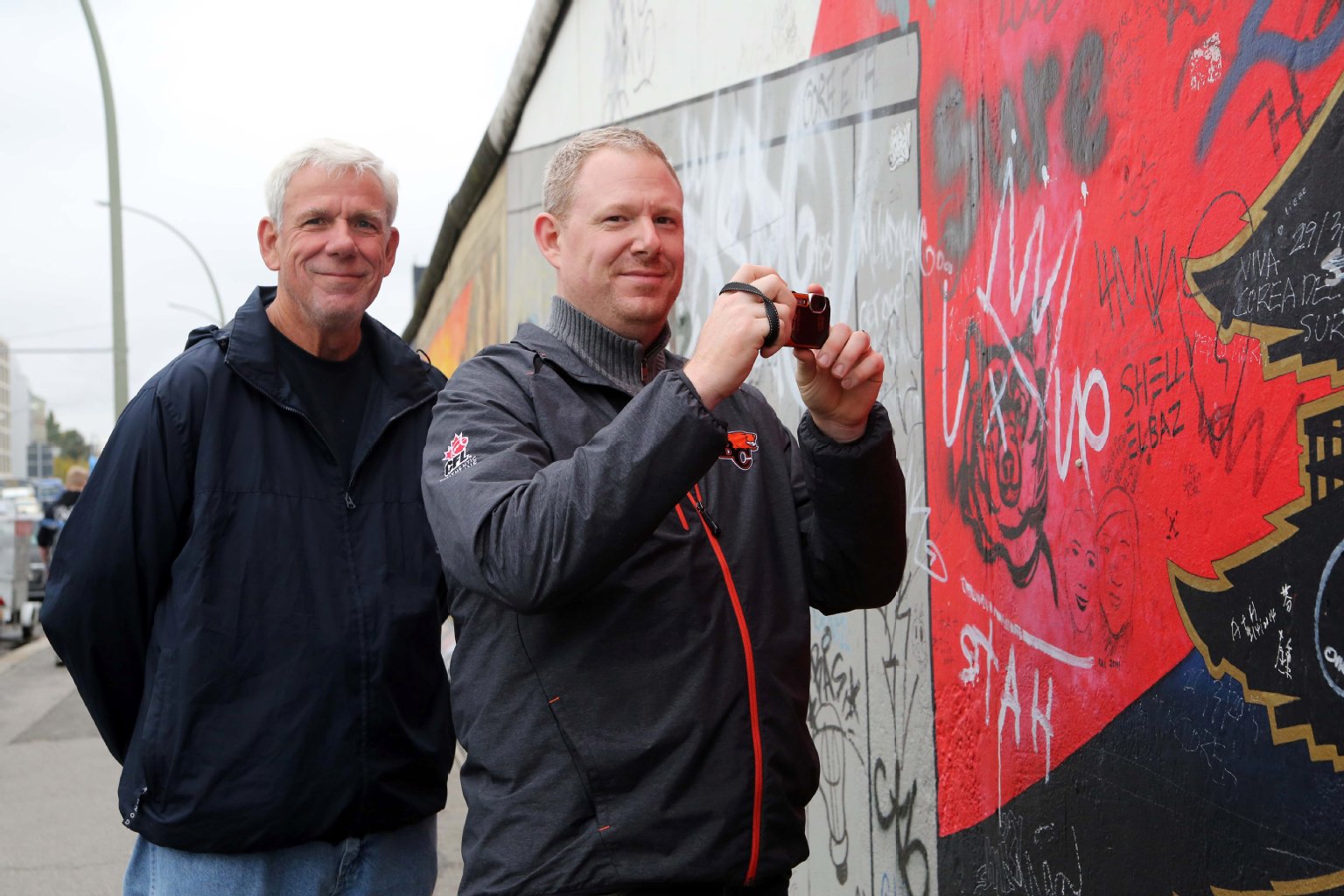 Thomas (65) und Sohn Derek Dubiellak (39) aus Kanada halten die Zaun-Pläne für sinnlos. „Das wird es für Sprayer nicht weniger attraktiv machen, ihre Tags an der Wand zu hinterlassen“, sagen sie. Derek sieht das Mauer-Denkmal zum ersten Mal. „Es ist schön – schade, dass so viele ihre Kritzeleien hinterlassen.“