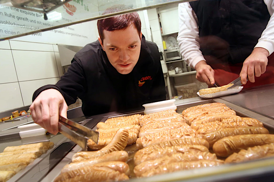 KURIER-Reporter Florian Thalmann bei seiner Schulung zum Currywurst-Experten.