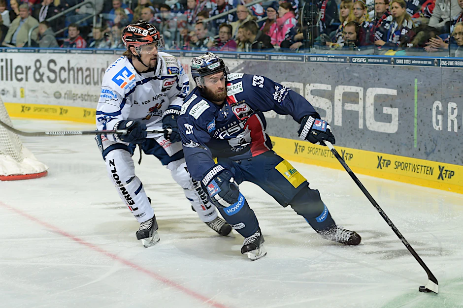 Petr Pohl von den Eisbären Berlin kontrolliert den Puck gegen Colten Teubert von den Iserlohn Roosters.