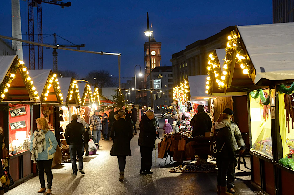 Oben leuchten die Kräne des Schlossbaustelle, unten die Lichterketten an den Ständen des Nostalgischen Weihnachtsmarkts. 