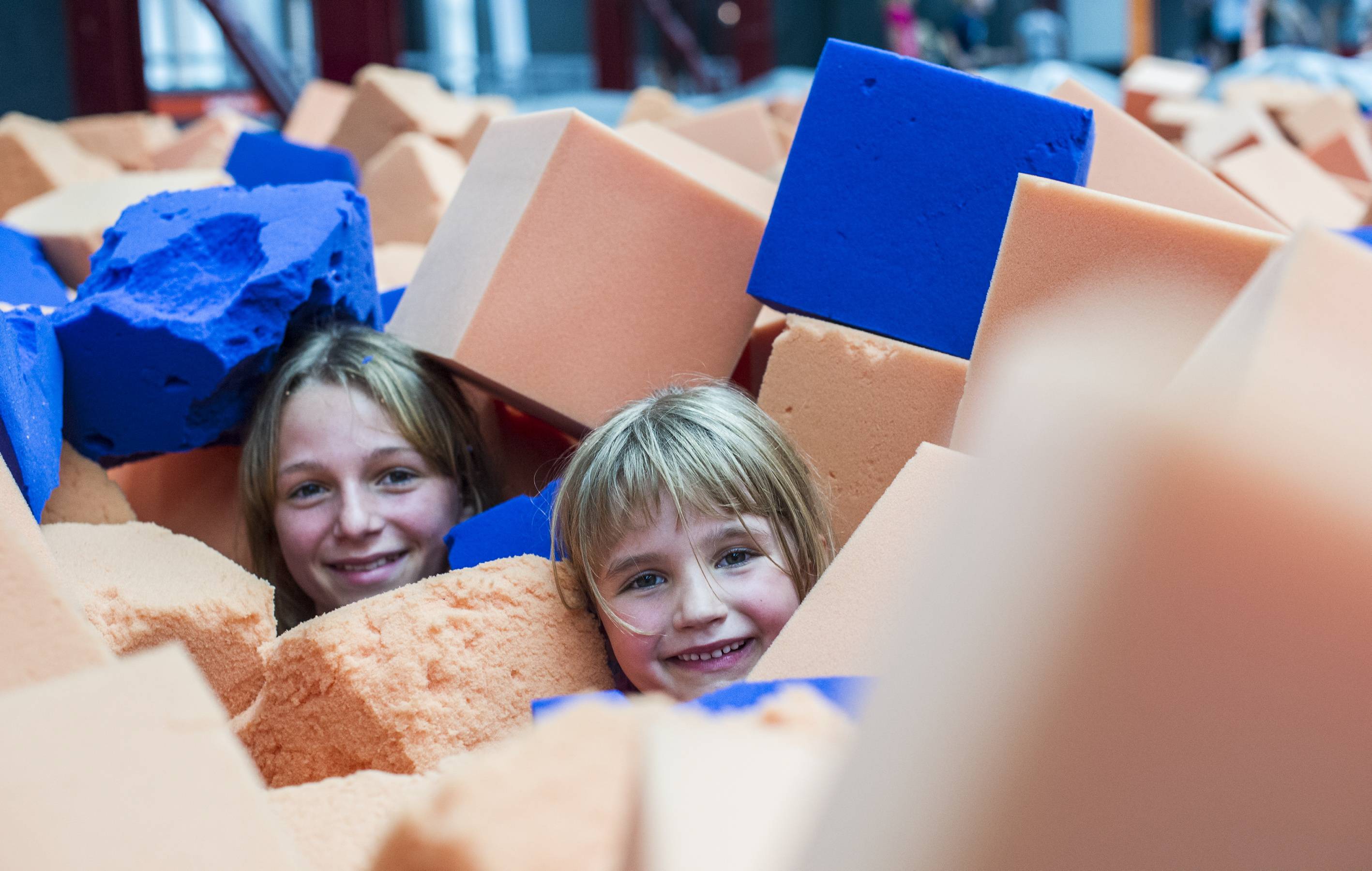 Amelie (12) und Jana (6) genießen das Abtauchen im Schaumstoffwürfel-Becken. Auch das Befreien aus der Riesen-Kiste ist Sport – so muss es sich anfühlen, im Treibsand zu stecken.