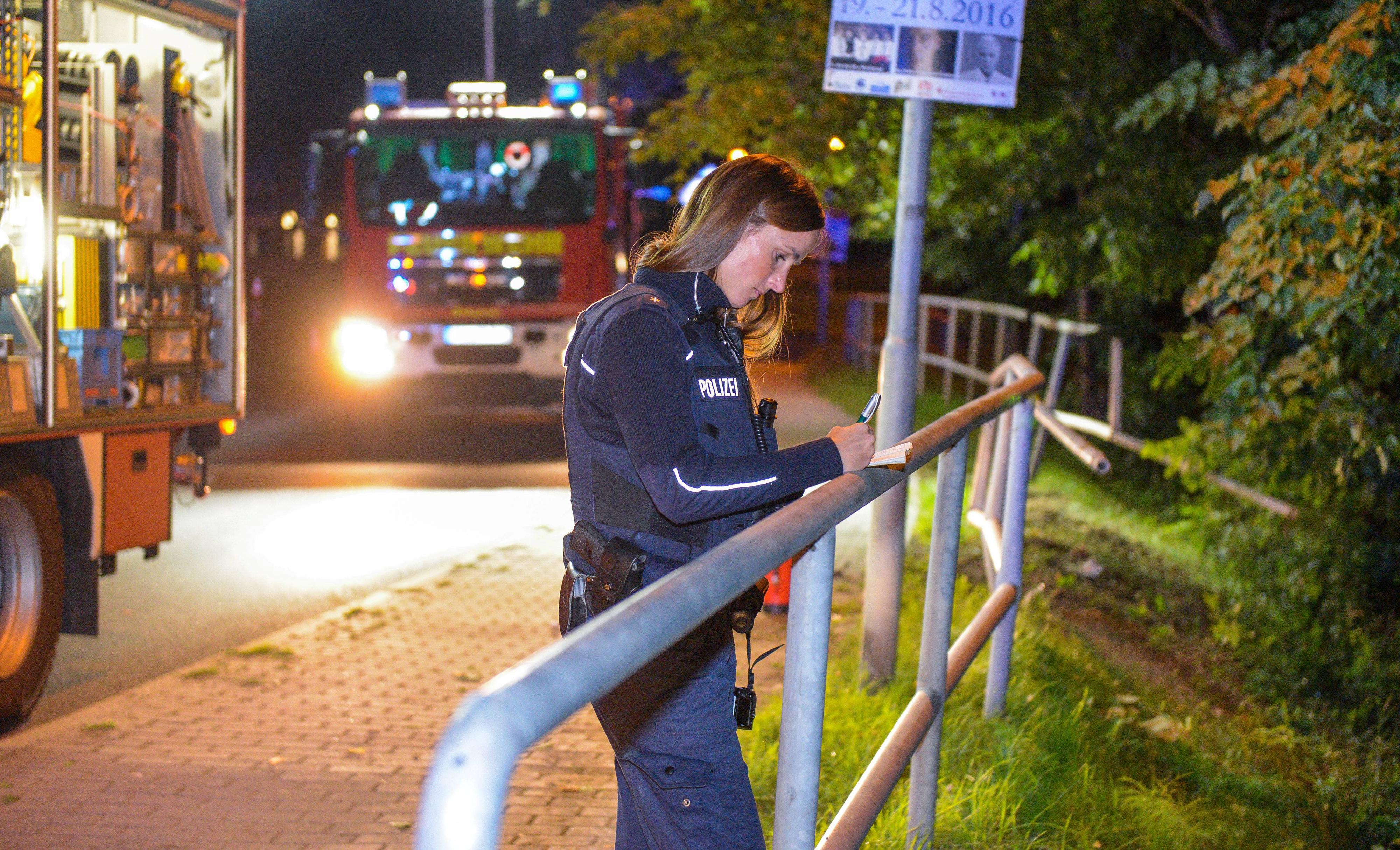 Eine Polizistin misst das kaputte Geländer, das das Auto durchschlug.