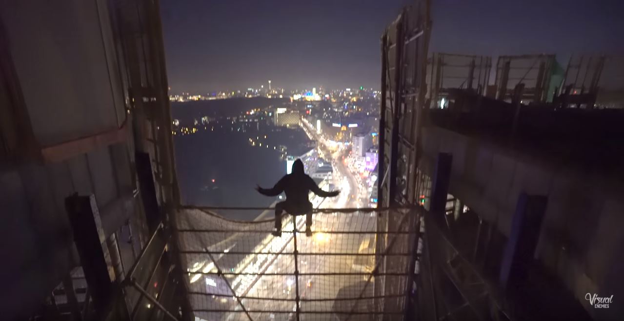 Freihändig posiert einer der beiden Kletterer auf einem Gitter der Baustelle. Die Aktion der beiden ist lebensgefährlich.