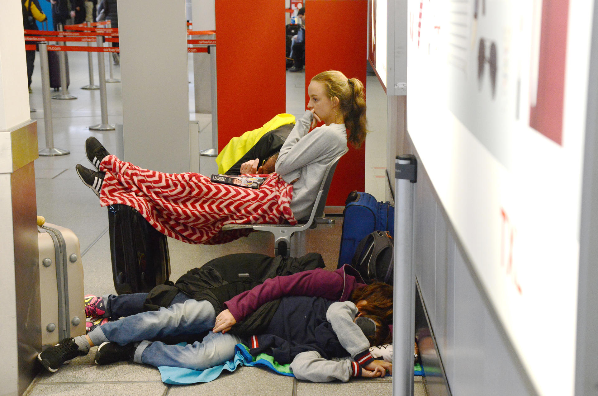 Viele Passagiere schlafen total erschöpft ein, weil sie so lange auf ihren Flug warten müssen.