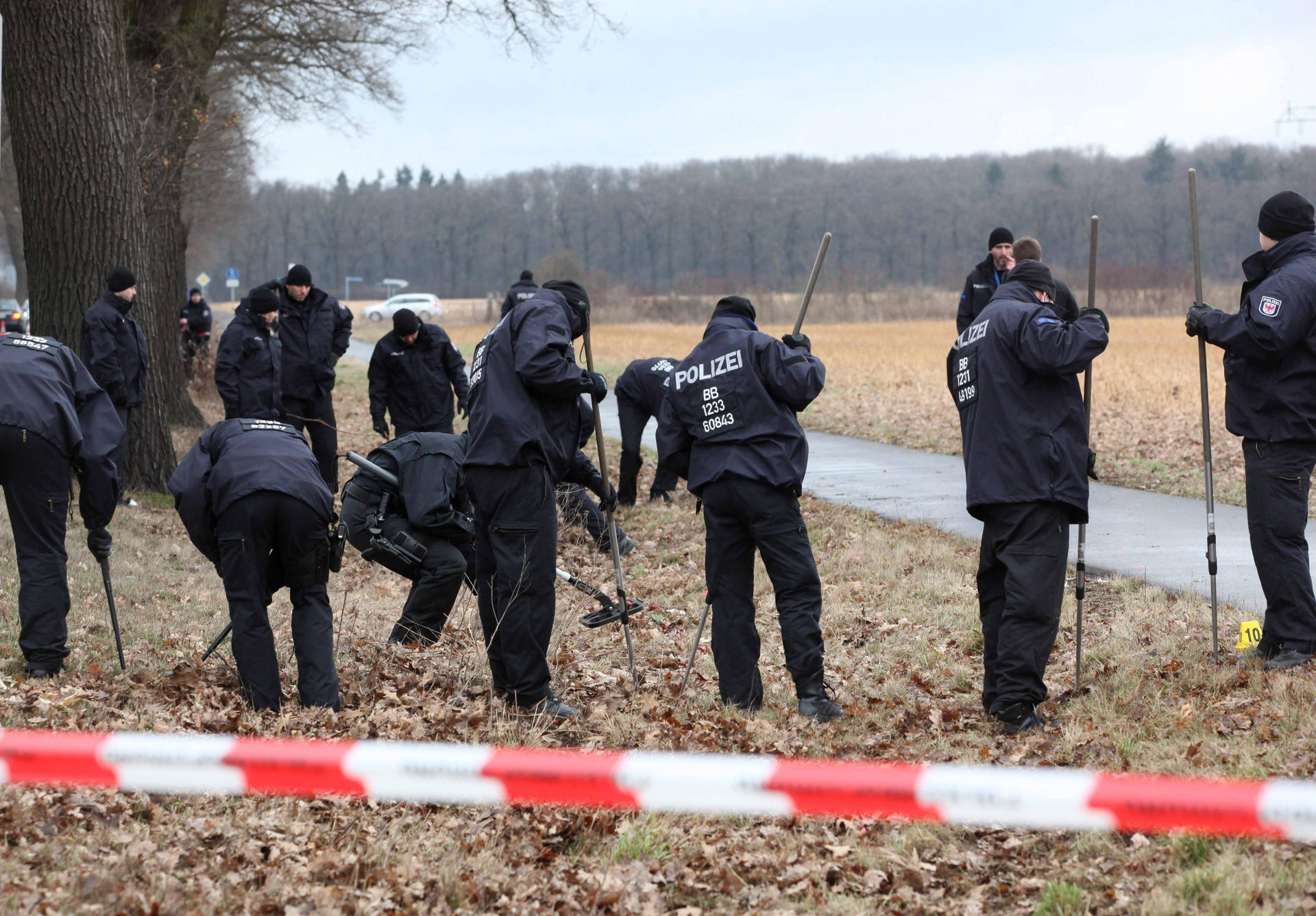 Spurensuche: Beamte durchkämmten mit Metalldetektoren die Wiesen neben dem Radweg, auf dem der mutmaßliche Täter zwei Polizisten überfahren hatte.
