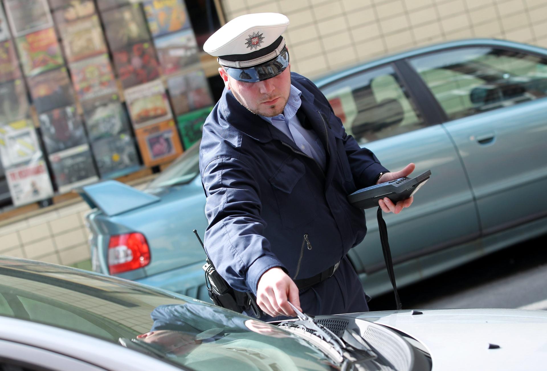 Ein Polizist verteilt in Strafzettel (Archivbild).
