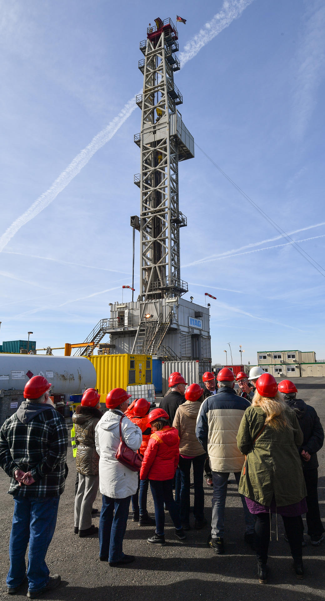 Besucher stehen vor dem Bohrturm auf der Bohranlage der deutsch-kanadischen Central European Petroleum GmbH.