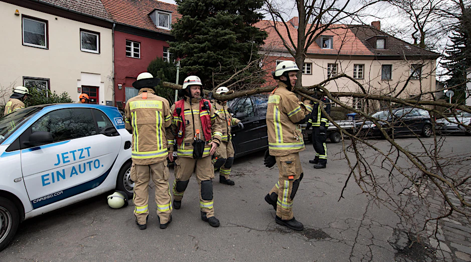 Feuerwehrleute beseitigen in Berlin-Tempelhof die Reste eines umgestürzten Baumes. 