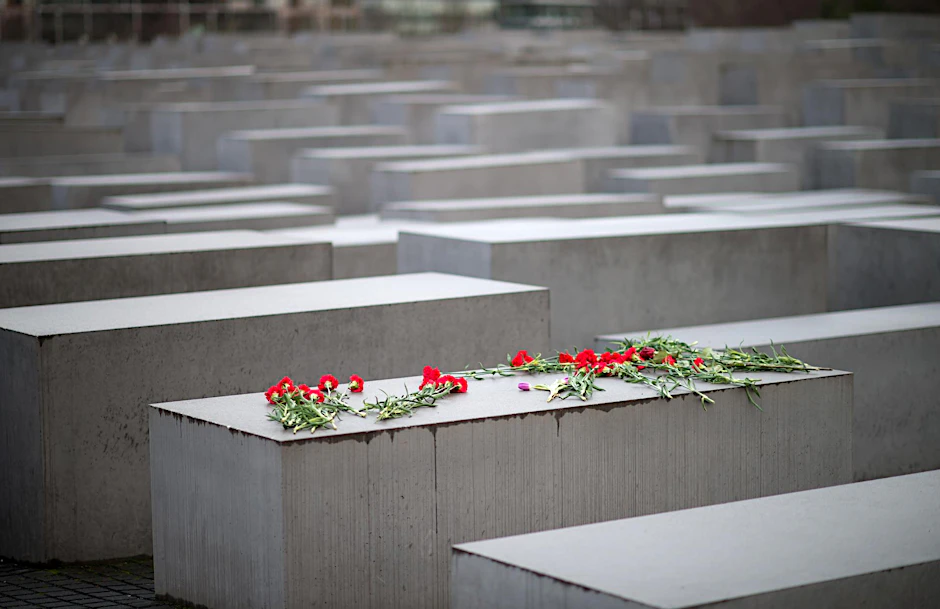 Blumen liegen auf einem Stein des Holocaust-Mahnmals in Berlin.