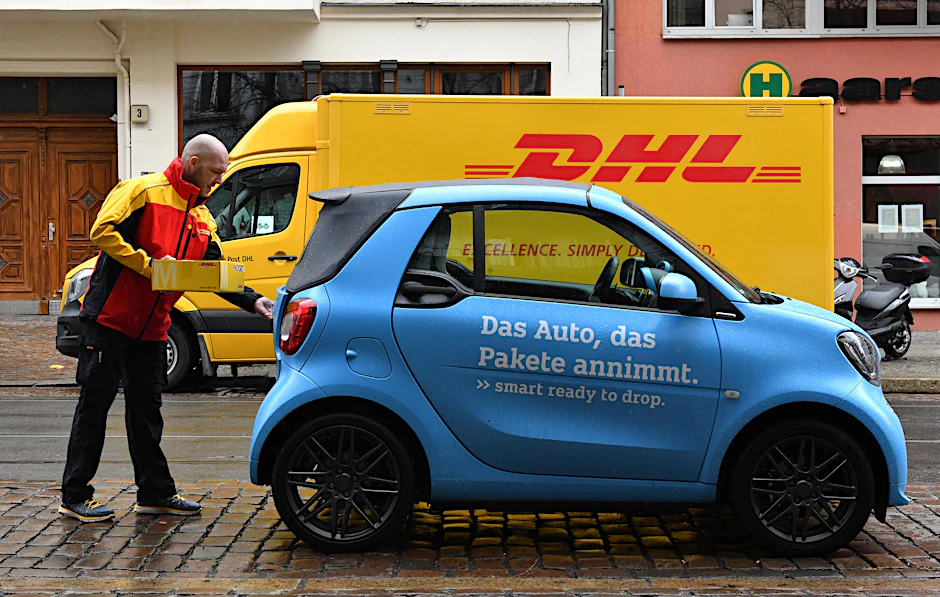 Und so geht’s: der Paketbote öffnet per Handy die Türen des Smart, legt das Paket hinein und verschließt das Auto wieder