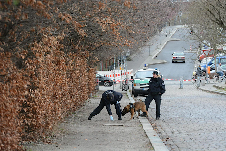 Mit einem Diensthund versuchen Polizisten, Duftspuren des Täters zu finden.