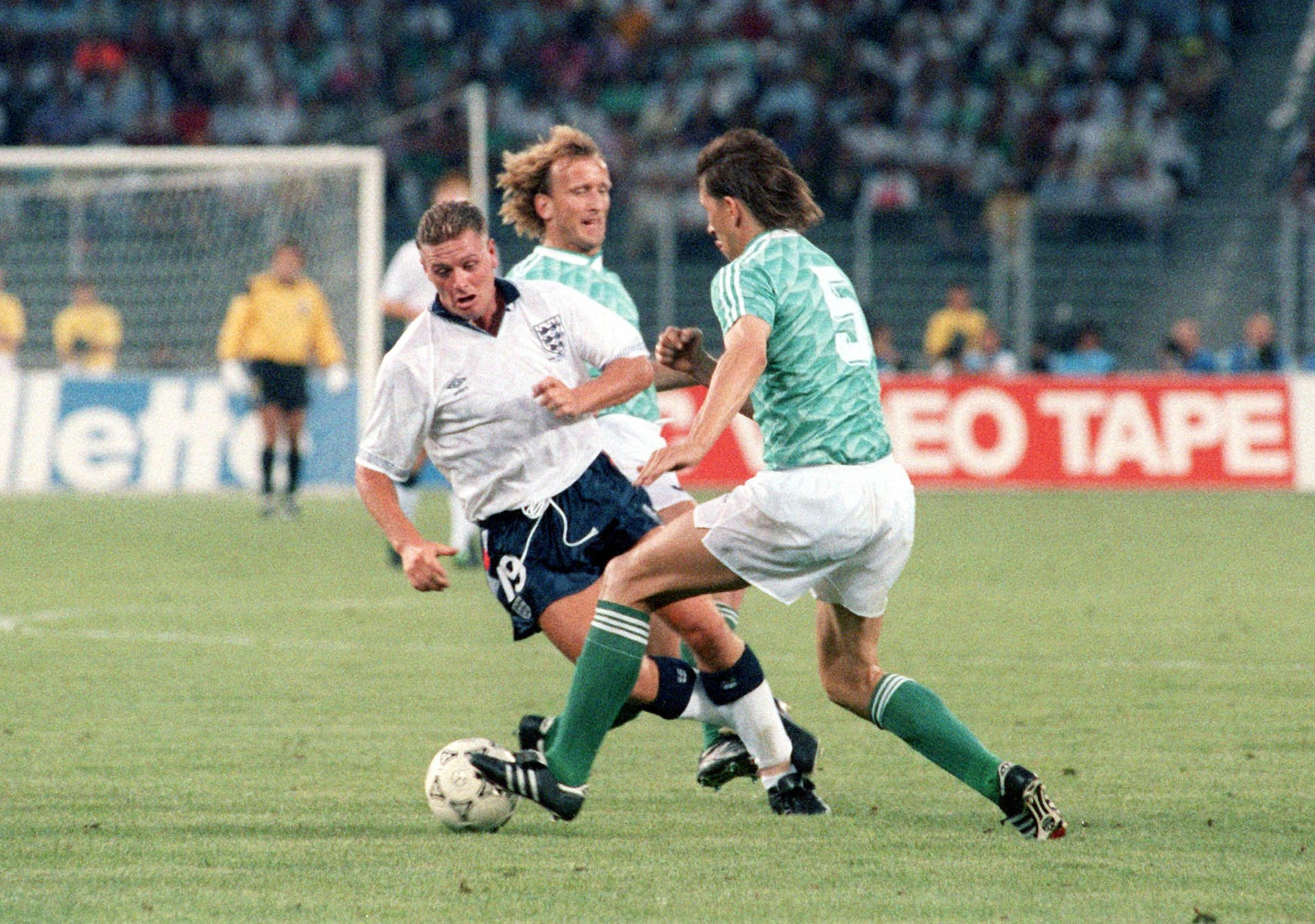 Andreas Brehme (M, hinten) und Klaus Augenthaler (r) versuchen den englischen Mittelfeldspieler Paul Gascoigne (l) beim WM-Halbfinale in Turin 1990 zu stoppen.