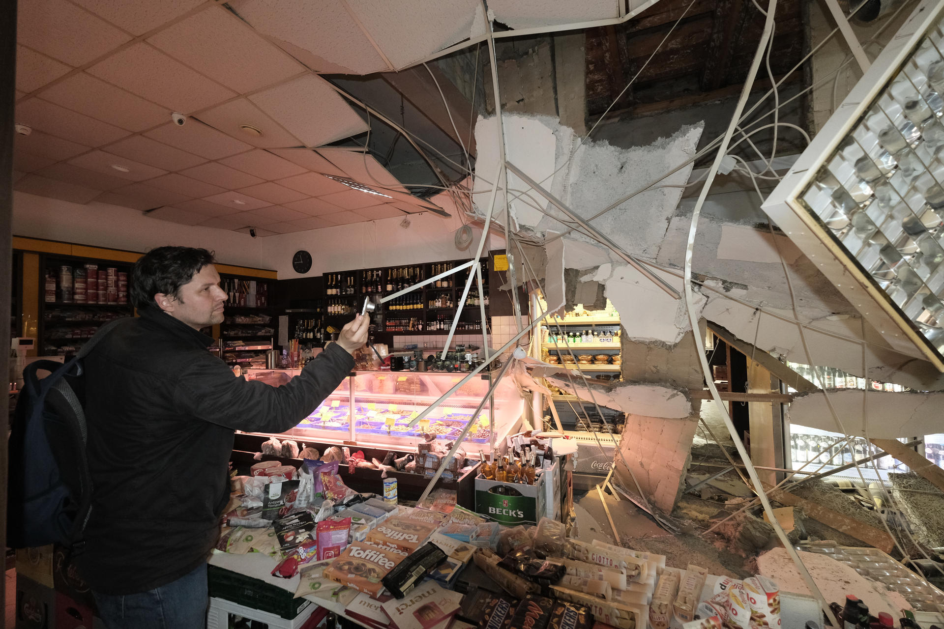 Ein Außendienstmitarbeiter der Bauaufsicht fotografiert die Schäden.