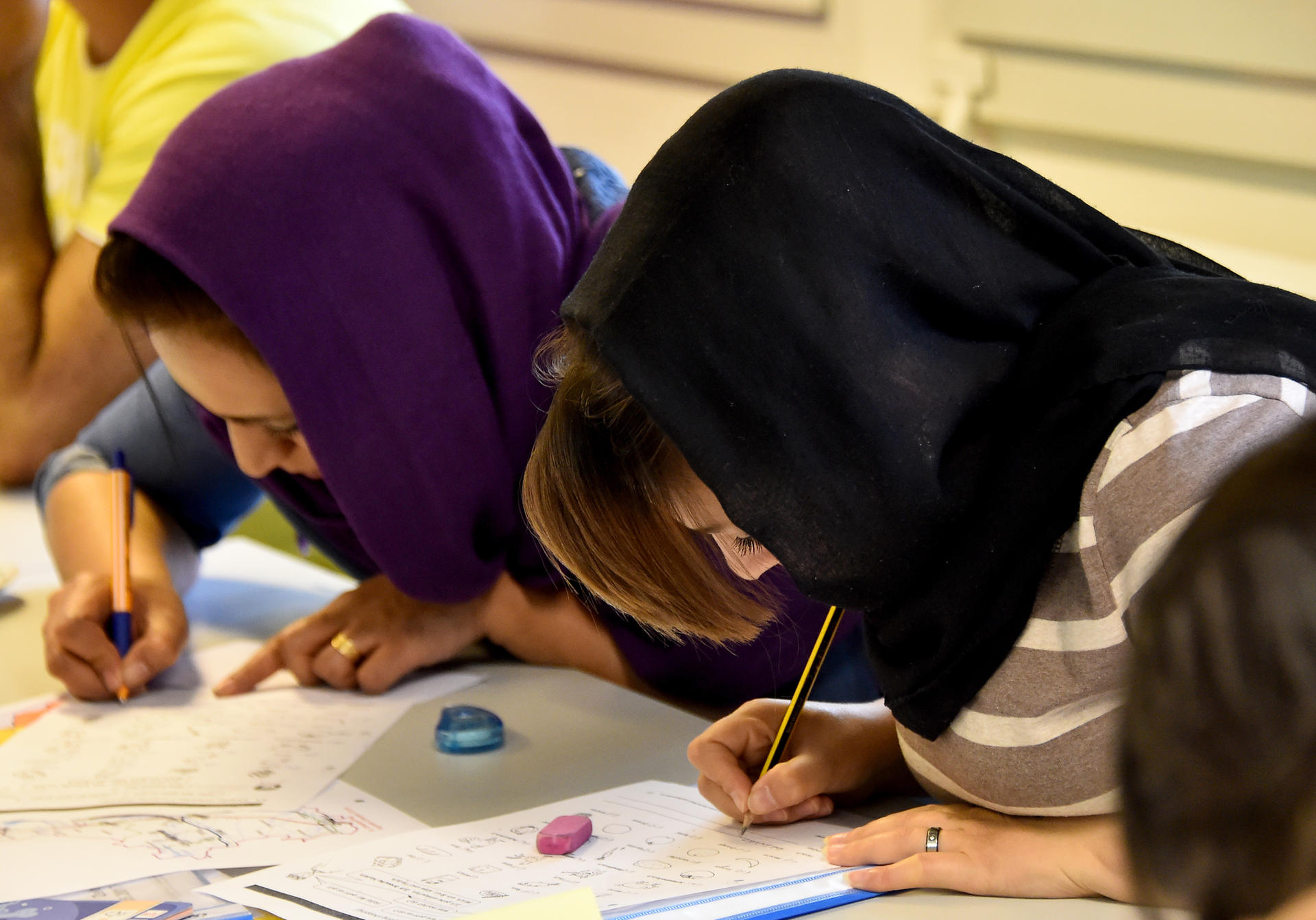 Zwei Frauen aus Afghanistan machen bei dem Landeskundekurs in Lauchhammer Aufzeichnungen.