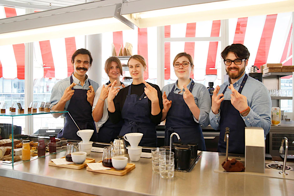Das Team von „The Barn“ im Café Kranzler kreuzt die Finger für Kundin Levina. Das ist Daumen-Drücken auf die britische Art.  