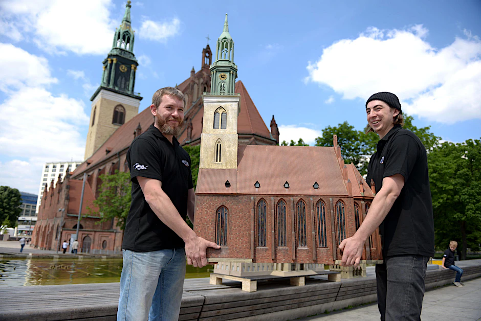 Joe (li.) und Eliott tragen das 30-Kilo-Modell der Marienkirche in die Schau. Im Hintergrund ist die echte.