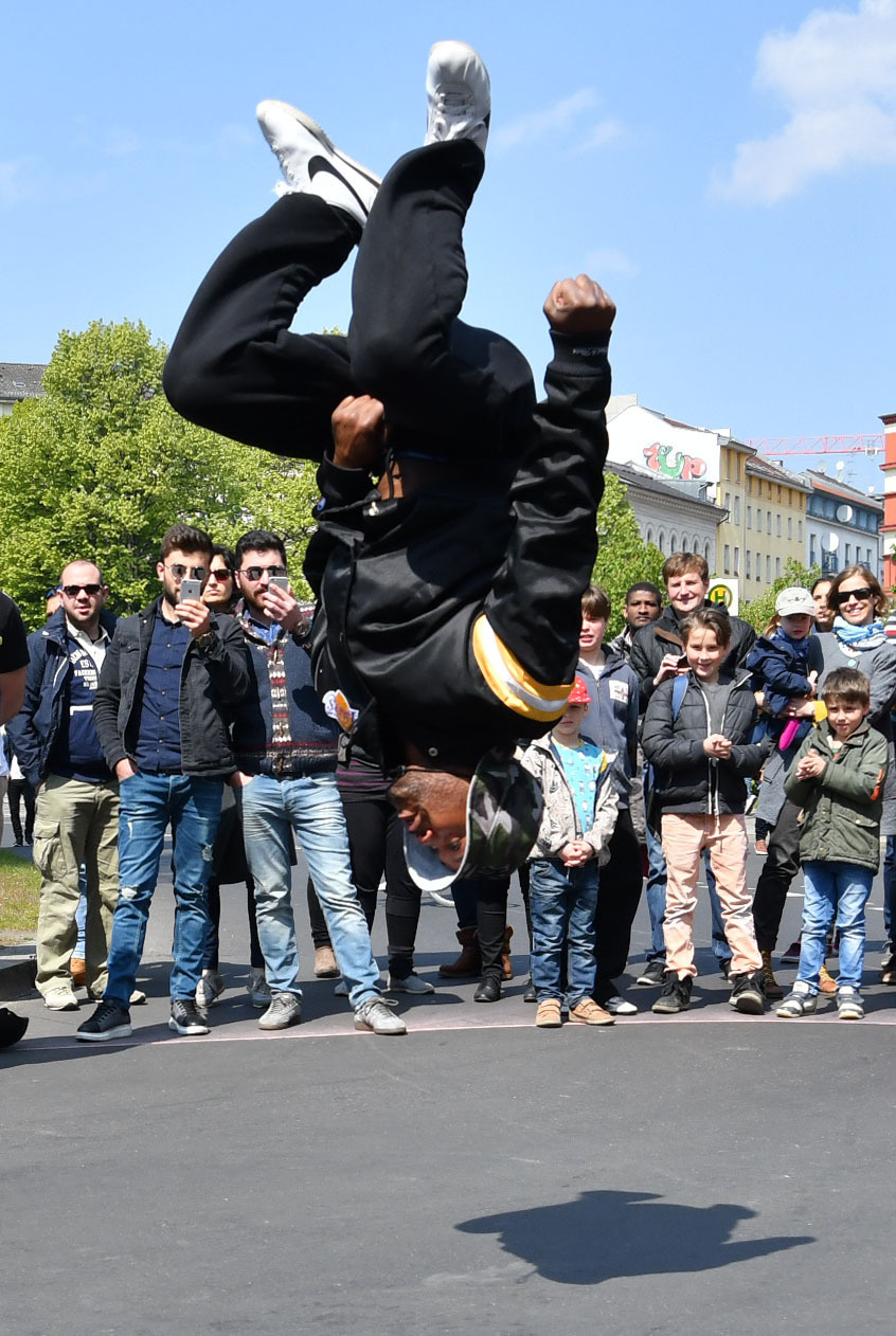 Ein Straßentänzer macht einen Salto.