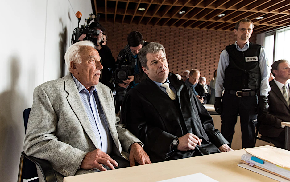 Sime J. (l.) vor Gericht –zu Prozessbeginn bat er die Opfer und deren Angehörige um Verzeihung. 