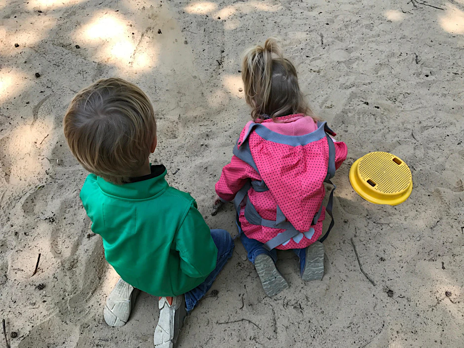 Kinder spielen in dem Sandkasten, in dem die Nadeln versteckt waren.