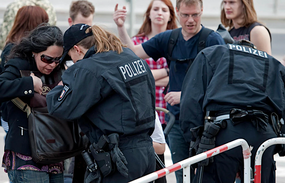 Dichte Polizeipräsenz am Tor. Eine Polizistin checkt die Tasche einer Frau.