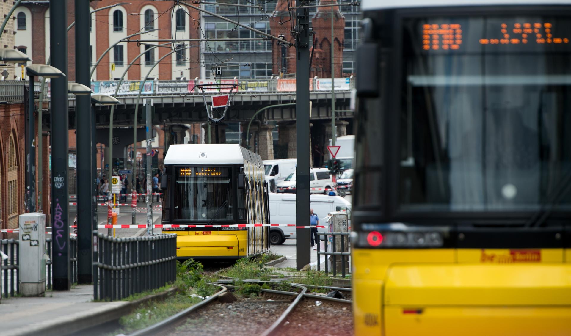 Zwei Straßenbahnen stehen am Montagmittag hinter einer Polizeiabsperrung an der Haltestelle Warschauer Straße. 