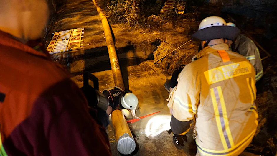 Feuerwehrleute versuchen den 60-Jährigen aus der Baugrube zu befreien - am Ende mit Erfolg.