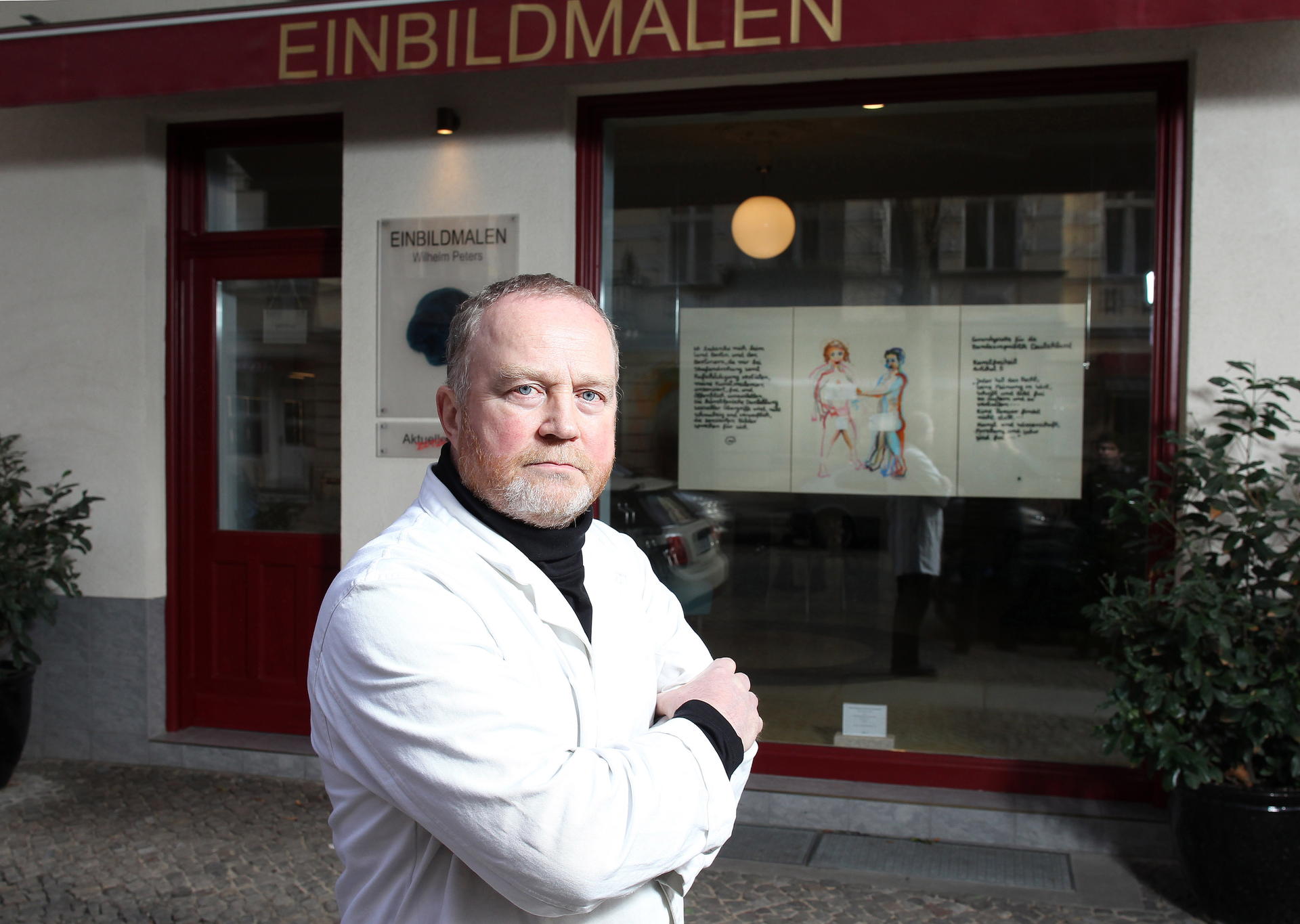 Peters (61) vor seinem Atelier in der Bleibtreustraße. Die Bilder sind beklebt. 