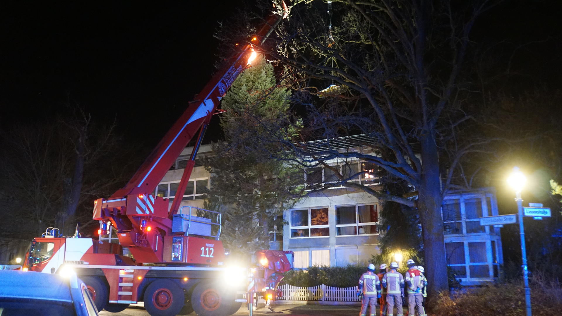 Der Spezialkran der Feuerwehr steht aufgebockt in der Hubertusbader Straße in Grunewald, am Haken hängt die 235-Kilo-Leiche. 