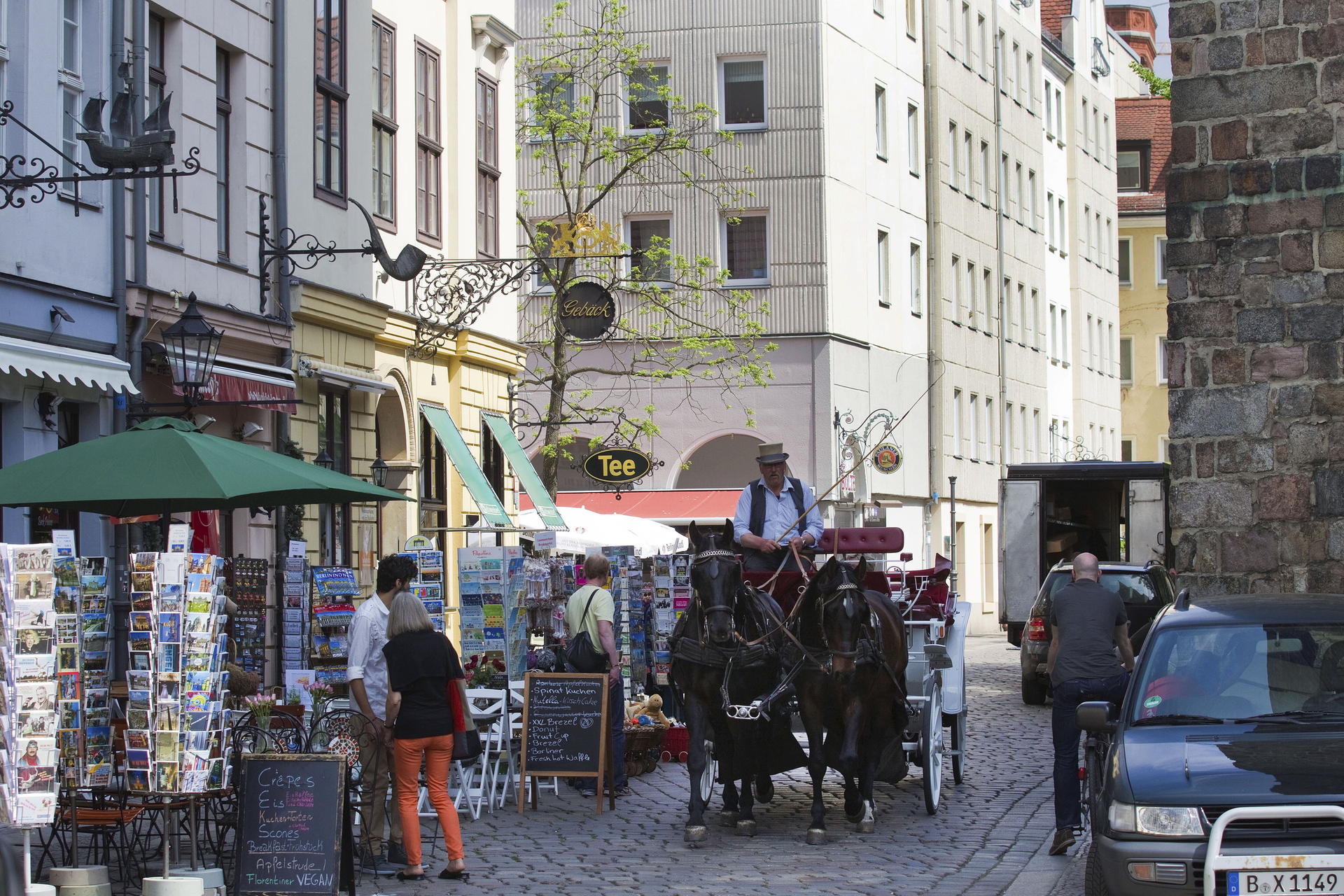Kutscher Ludwig Zachmann sorgt mit seiner Droschke für Altstadt-Feeling im Nikolaiviertel. Die Geschäfte bieten Postkarten für die Berlin-Touristen an. 