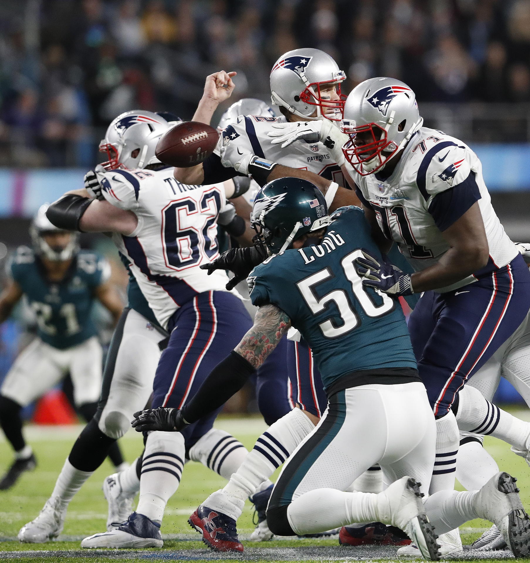 Philadelphias Brandon Graham (nur der Arm sichtbar) schlägt New Englands Tom Brady (oben) den Ball aus der Hand. 