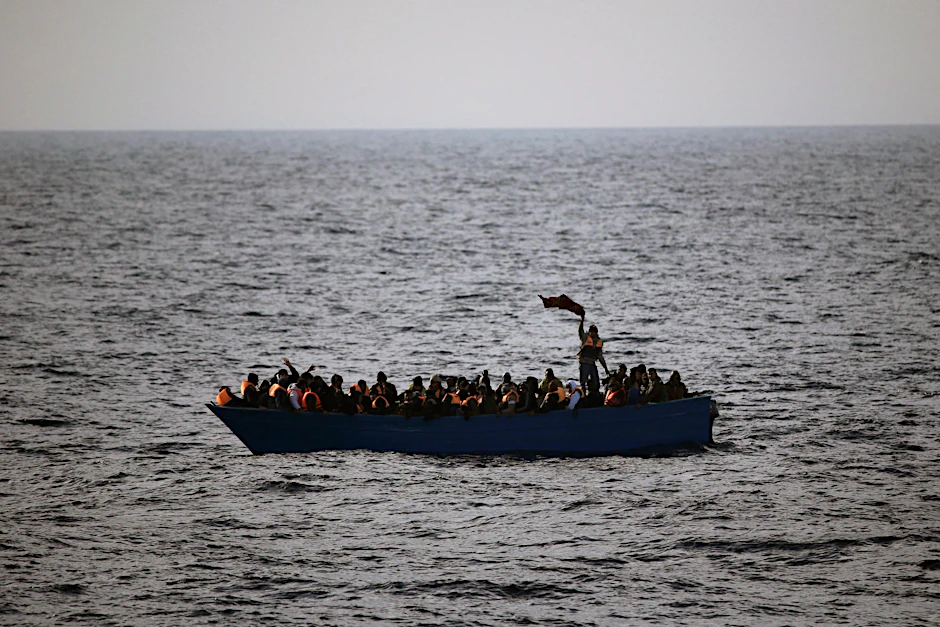 In einem kleinen Holzboot zusammengepferchte Flüchtlinge auf offener See vor der Küste Libyens. 