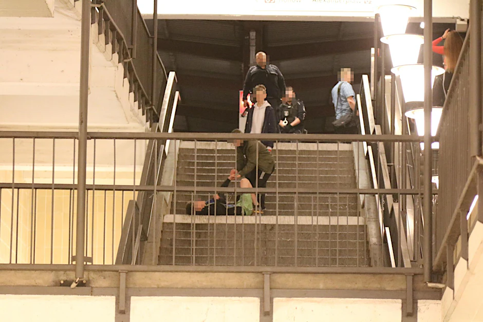 Die Schlägerei verlagerte sich bis zur Treppe. Ein Jugendlicher versucht, seinem verletzten Freund auf die Beine zu helfen.