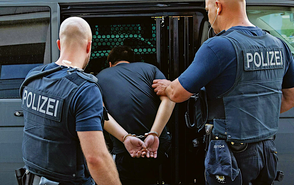 Bundespolizisten bringen Bandenchef Minh B. in Handschellen in einen Gefangenentransporter.