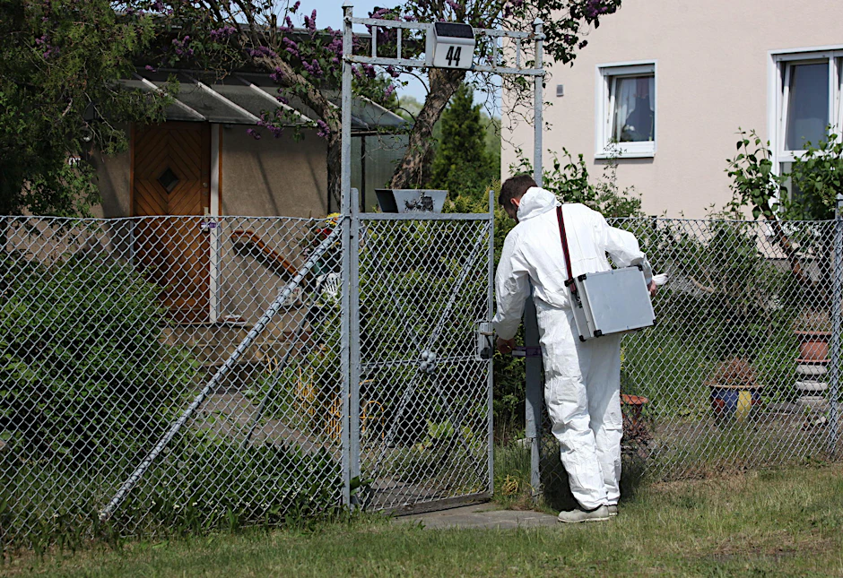 Ein Ermittler der Spurensicherung vor dem Mordhaus.