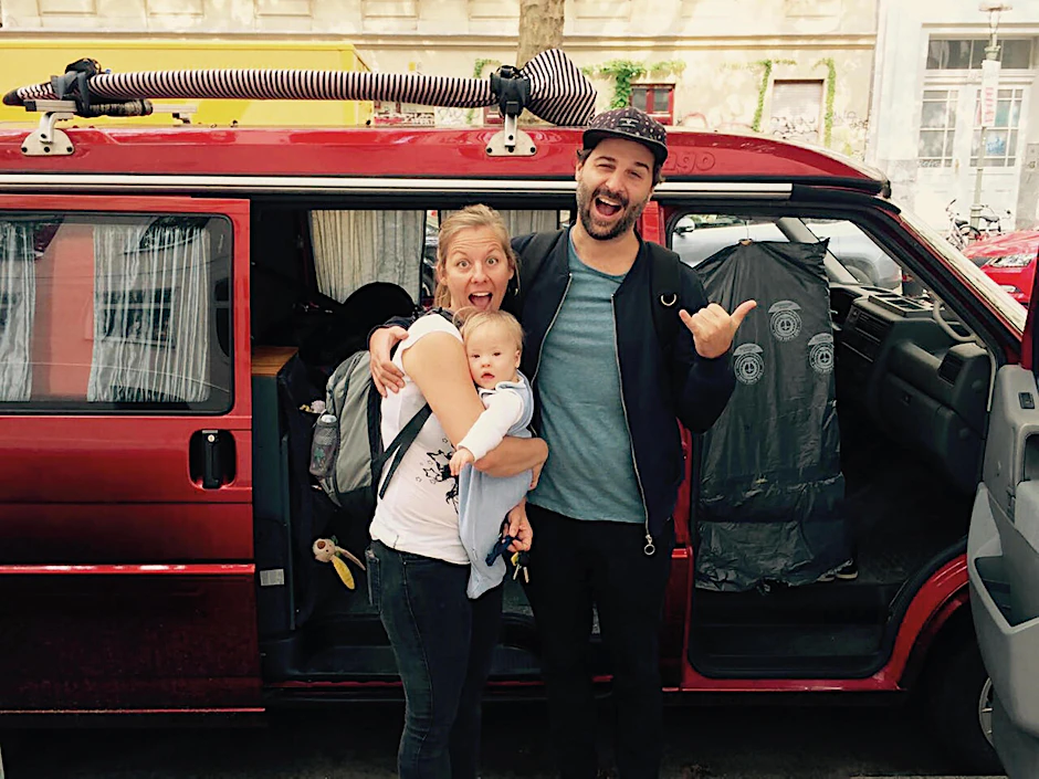 Die kleine Familie mit ihrem feuerroten Abenteuer-Mobil.