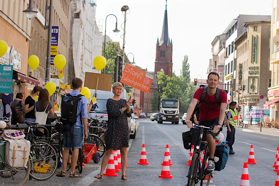 Ballons, Schilder und ein Radweg aus Absperrhütchen auf der Karl-Marx-Straße.