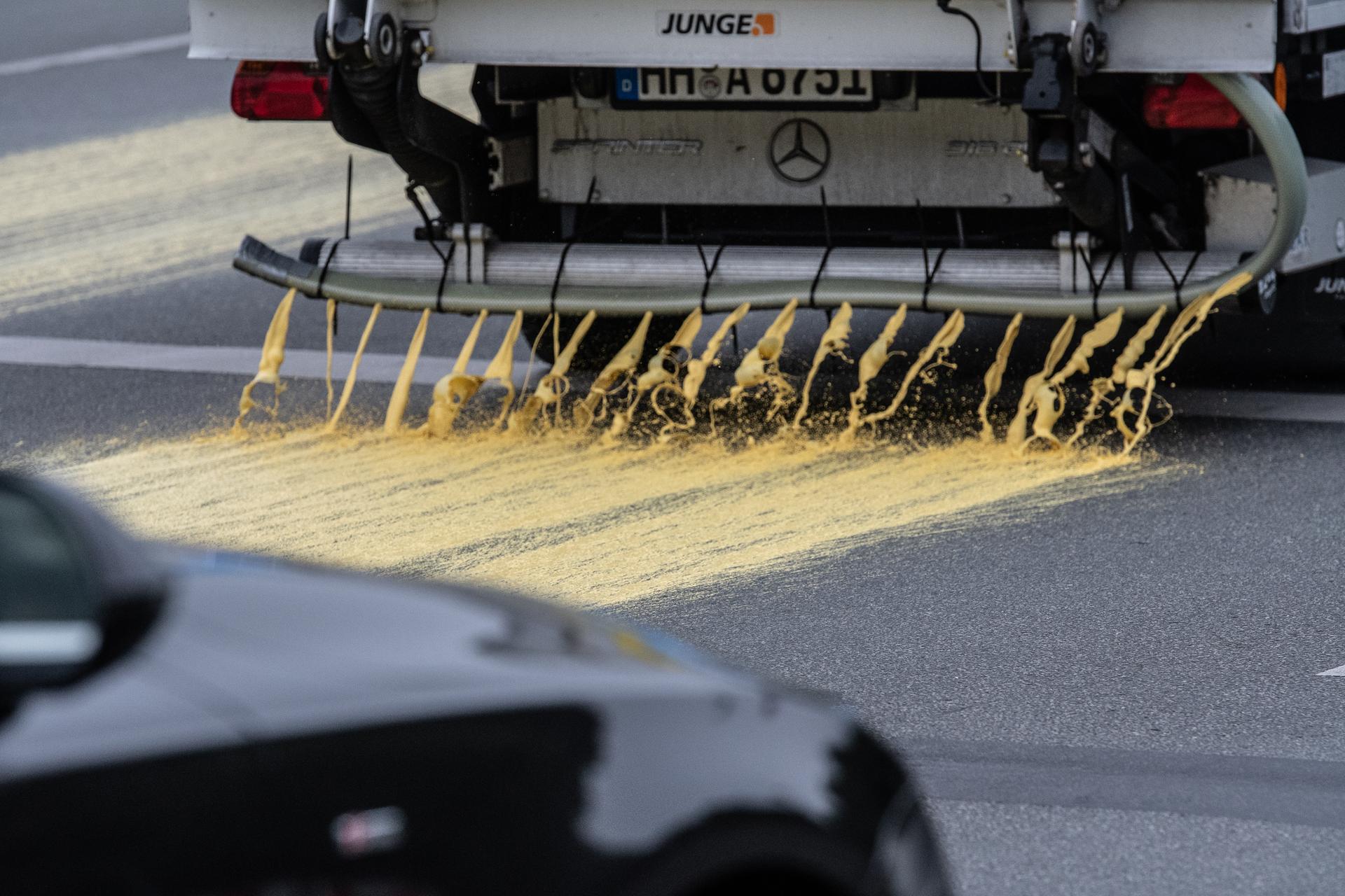 Zunächst wurde diese mit Düsen per Lastkraftwagen auf die Straße aufgetragen. 