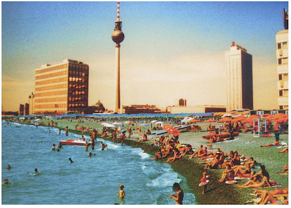 Der Fernsehturm und die Skyline Ost erheben sich über einen italienischen Badestrand. 